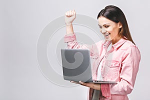 Portrait of attractive surprised excited smiling business woman hold hand up looking at laptop screen, isolated over white