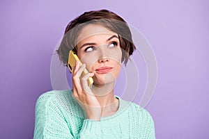 Portrait of attractive suspicious doubtful brown-haired girl calling using celllular isolated over violet purple color