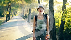 Portrait of Attractive tourist girl smiling and looking into camera while walking and hiking beautiful forest