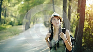 Portrait of Attractive tourist girl smiling and looking into camera while walking and hiking beautiful forest