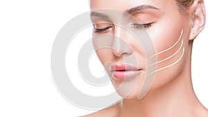 Portrait of attractive woman with arrows on her face over white background. Face lifting concept. Plastic surgery