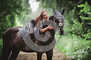 Portrait of attractive woman and black hanoverian stallion horse