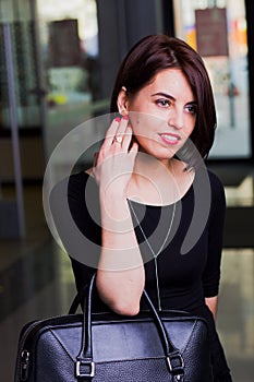 Portrait attractive woman with a briefcase in a mall