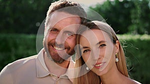 Portrait of attractive woman and handsome man smiling at camera outdoors