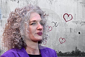 Woman with wonderful hair in front of a wall with graffiti hearts