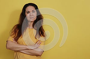 Portrait of an attractive woman in a yellow T-shirt on a studio background.