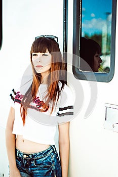 Portrait attractive women in sports white T-shirt against background of Camper Trailer photo