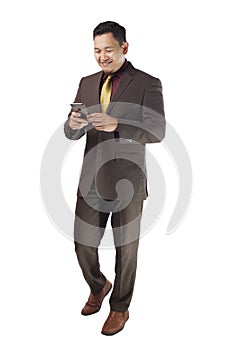 Attractive young businessman reading message on his phone, happy smiling