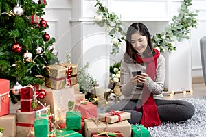 Portrait of attractive young asian woman or teenage girl smiling and looking at smartphone mobile chatting or using social media