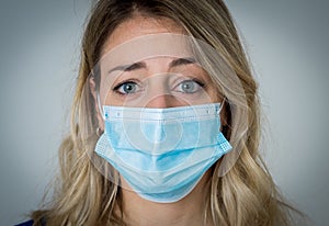 Portrait of attractive young happy woman with protective face mask isolated on neutral background