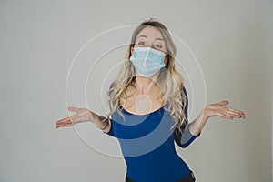 Portrait of attractive young happy woman with protective face mask isolated on neutral background