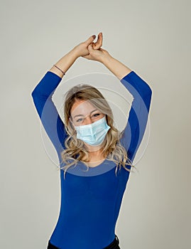 Portrait of attractive young happy woman with protective face mask isolated on neutral background