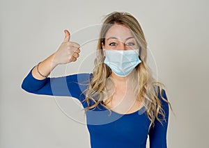 Portrait of attractive young happy woman with protective face mask isolated on neutral background