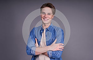 Portrait of an attractive young man standing with arms crossed