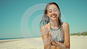 portrait of attractive young mixed race woman laughing cheerful enjoying sunny day on calm sandy beach feminine beauty