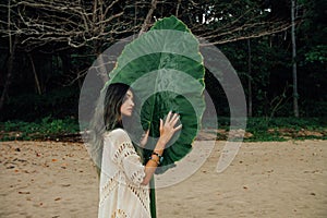 Portrait attractive young woman on background large green leaf tropical tree