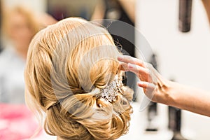 Portrait of attractive young woman with beautiful hairstyle and stylish hair accessory, rear view.