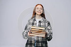 Portrait of attractive young woman college student holding book and looking at camera.