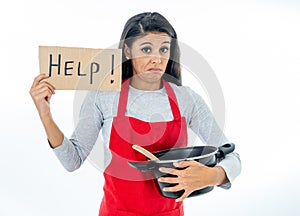 Portrait of attractive young woman cooking wearing a red apron holding a help sign