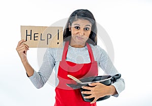 Portrait of attractive young woman cooking wearing a red apron holding a help sign