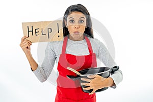 Portrait of attractive young woman cooking wearing a red apron holding a help sign