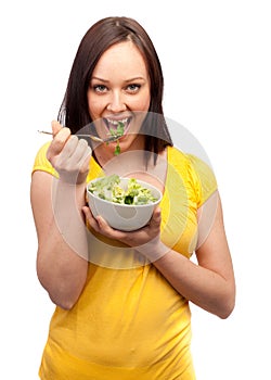 Portrait of an attractive young woman eating salad