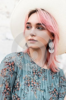 Portrait attractive young woman in fashionable white hat in blue stylish summer beautiful dress with vintage earrings near