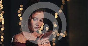 Portrait of a attractive young woman girl who looks at the phone and smiles. new year-Christmas. birthday. holiday. the