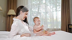 Portrait of attractive young woman with her adorable child on bed. Happy maternity concept. loving happy mother hugs 8