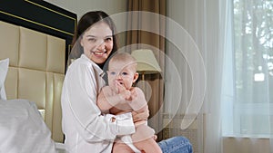 Portrait of attractive young woman with her adorable child on bed. Happy maternity concept. loving happy mother hugs 8