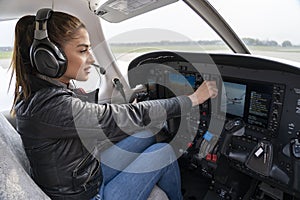 Portrait of Attractive Young Woman Pilot With Headset in the Cockpit