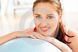 Portrait of attractive young woman relaxing fitness ball at gym