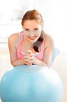 Portrait of attractive young woman relaxing fitness ball at gym photo