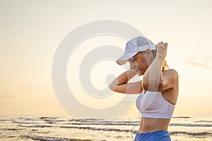 portrait of an attractive young woman running along the beach and listening to music on headphones.