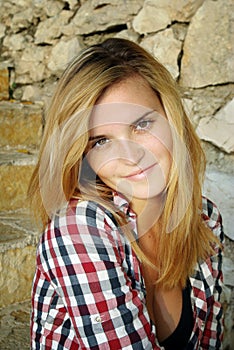 Portrait of attractive young woman and stone wall