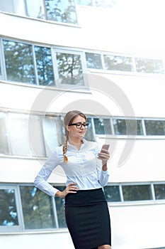 Portrait of an attractive young woman walking and looking at mobile phone