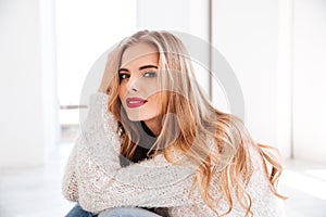 Portrait of attractive young woman wearing sweater and red lipstick