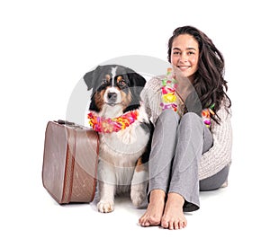 Portrait of an Australian shepherd with suitcase and with his mistress