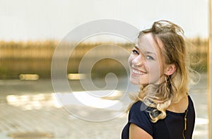 Portrait of an austrian young blonde woman turning her head, smiling