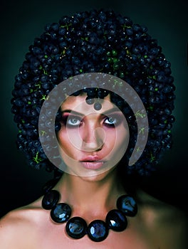 Portrait of Autumn Woman with Grapes on her Head. Trendy Hairstyle