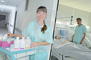 portrait auxiliary nurse with trolley outside patients room