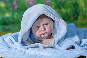 Portrait of a baby in a blue towel.