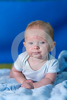 Portrait of a baby in a blue towel.