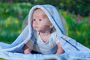 Portrait of a baby in a blue towel.