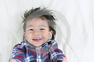 Portrait Baby Boy Asia Smile on Bed with space for text.