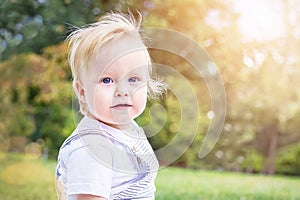 Portrait of baby (boy) in the casuals clothing. Healthy child (kid) is enjoying summer day at the park. photo