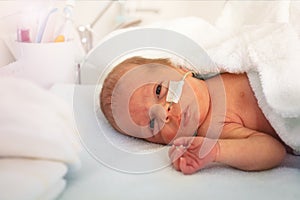 Portrait of a baby boy in ICU hospital crib