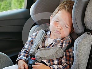 Portrait of baby boy sleeping in a car seat. Safe childhood concept.