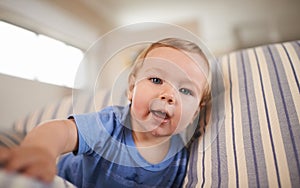 Portrait, baby boy and smile in sofa relaxing, resting and playing in living room. Newborn, growth and development at