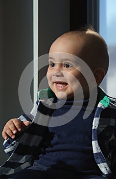 portrait of a baby boy wearing casual shirt and smiling